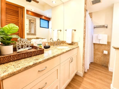 The bathroom features stone tile finishes and ample counter space