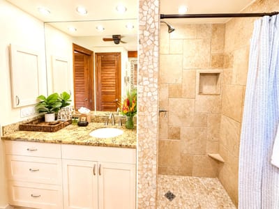 The bathroom features a neutral tone walk in shower