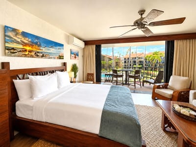 The suite features a king bed dressed in crisp white linens