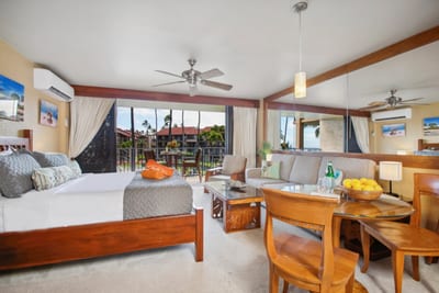 This guest suite pairs a rich wood bed with open views, soft lighting, and island flair in every corner