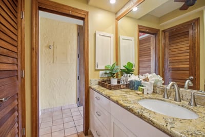 Thoughtfully designed with dual vanities, warm tile flooring, and glowing lighting for a relaxed, spa-like atmosphere