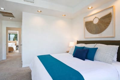 Sink into a cloud of calm—this master bed is framed by glass, greenery, and serene neutral tones