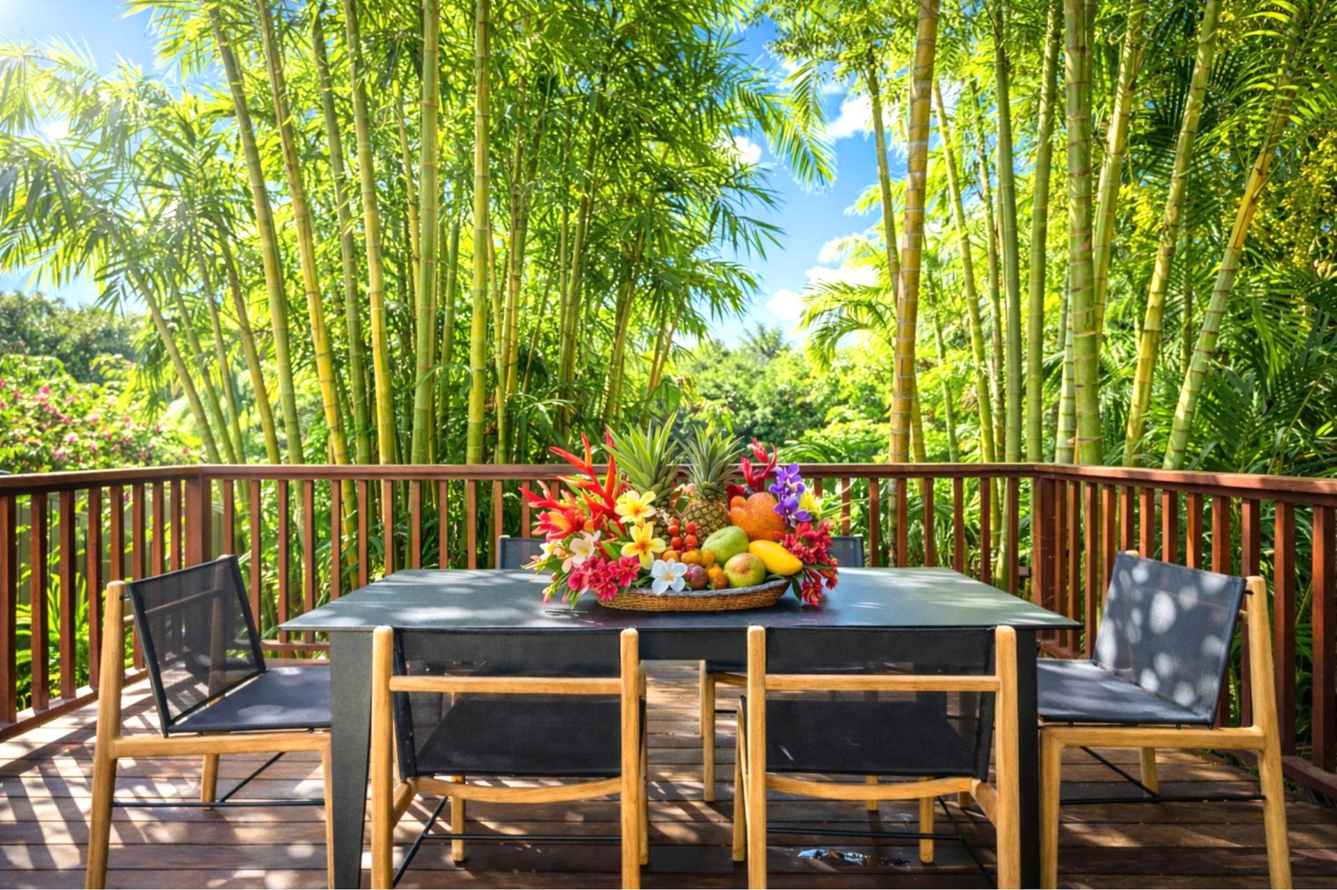 Surrounded by lush tropical foliage, this serene lanai offers the perfect spot for peaceful dining in nature’s embrace   