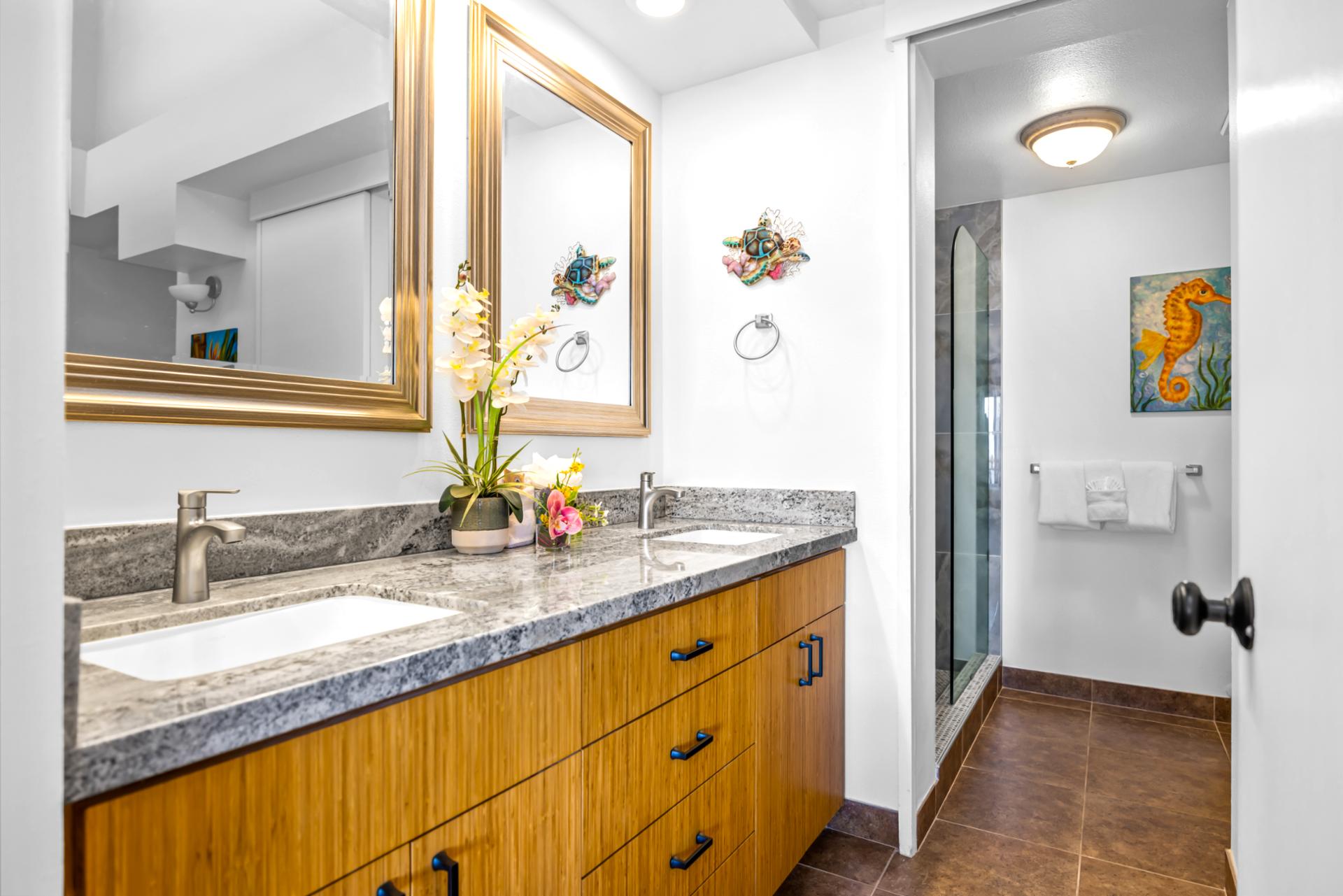 The primary bath includes a granite vanity, walk-in shower, and L’Occitane amenities for a spa-like experience.