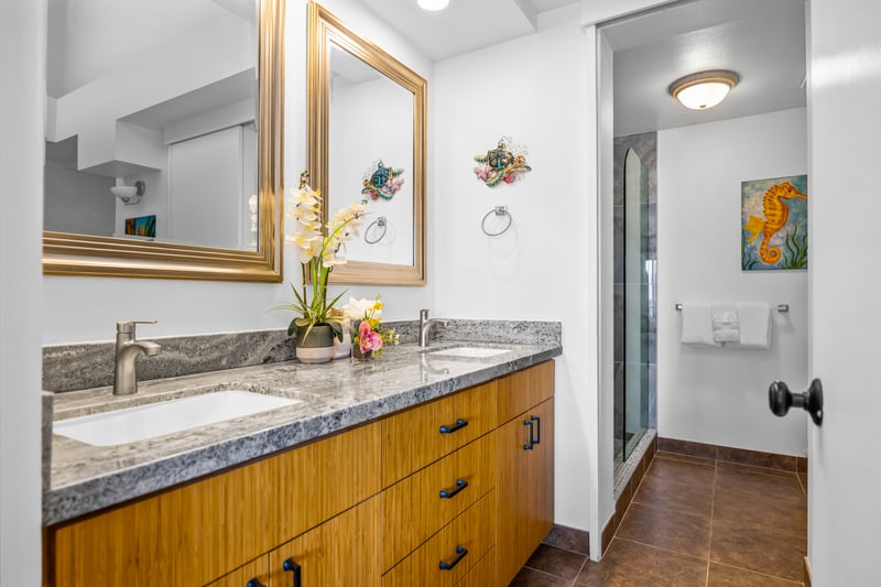 The primary bath includes a granite vanity, walk-in shower, and L’Occitane amenities for a spa-like experience.