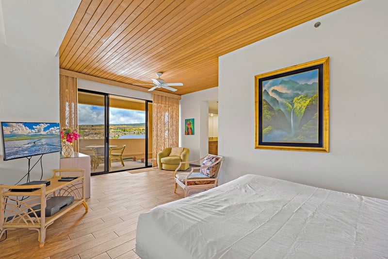 A peaceful master bedroom retreat with vaulted wood ceilings, a plush king bed, and sweeping ocean and sky views