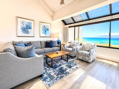 A bright, open living area with comfortable seating and direct access to the ocean-facing lanai