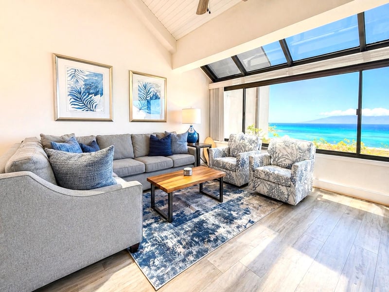 A bright, open living area with comfortable seating and direct access to the ocean-facing lanai