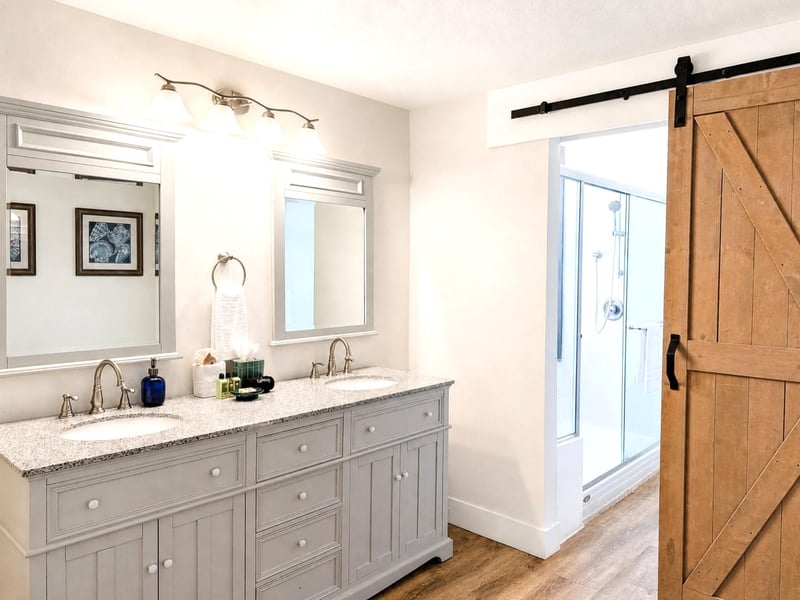 The second guest bath features bright lighting and dual washbasins, perfect for getting ready or winding down