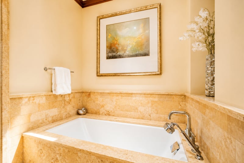 A soaking tub set beneath soft lighting makes this guest bath a serene escape
