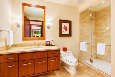 Clean and elegant, this bathroom includes a large glass walk in shower and soft lighting