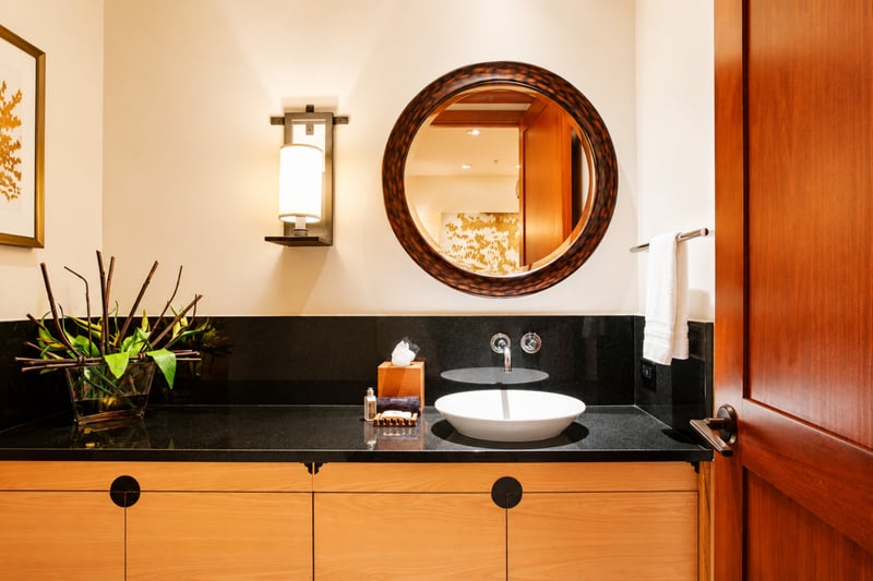 Unique accents and a stylish round mirror give this guest bathroom a designer feel