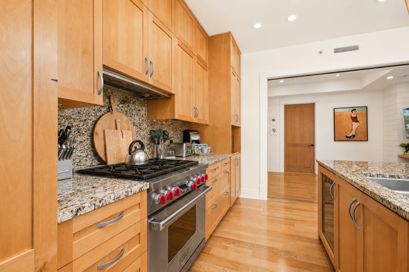 Kitchen prep station at The Resort at Kapalua Bay MON-2206 — gas range, custom cutting boards, and granite counters throughout MON-2206