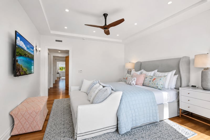 Primary bedroom at The Resort at Kapalua Bay MON-2206 — smart TV, coral bench, and direct hallway access MON-2206