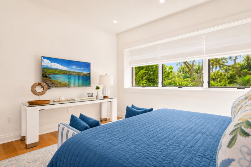 Guest bedroom at The Resort at Kapalua Bay MON-2206 — blue accent pillows and a wall-mounted TV facing the bed MON-2206