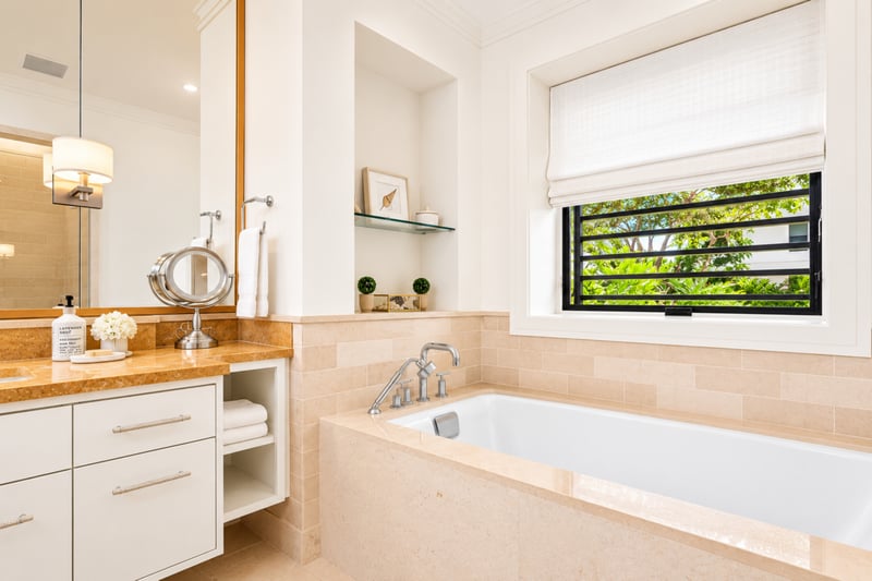 Guest bathroom at The Resort at Kapalua Bay MON-2206 — soaking tub and vanity beneath louvered wood shutters