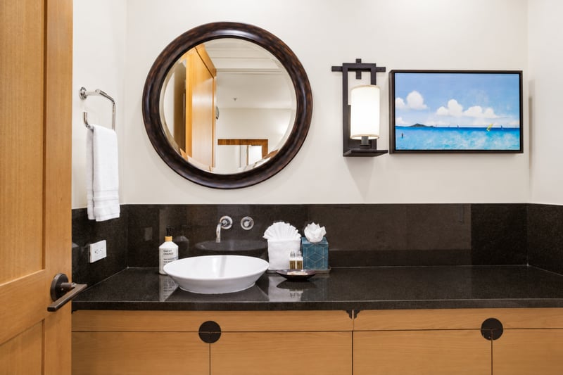 Powder room at The Resort at Kapalua Bay MON-2206 — black granite vessel sink beneath a framed ocean painting