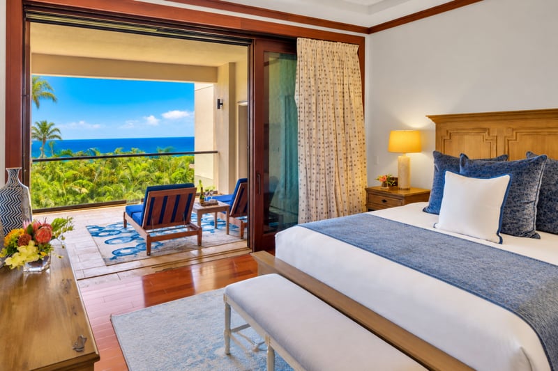 Primary bedroom with private lanai access, lounge chairs, and ocean views