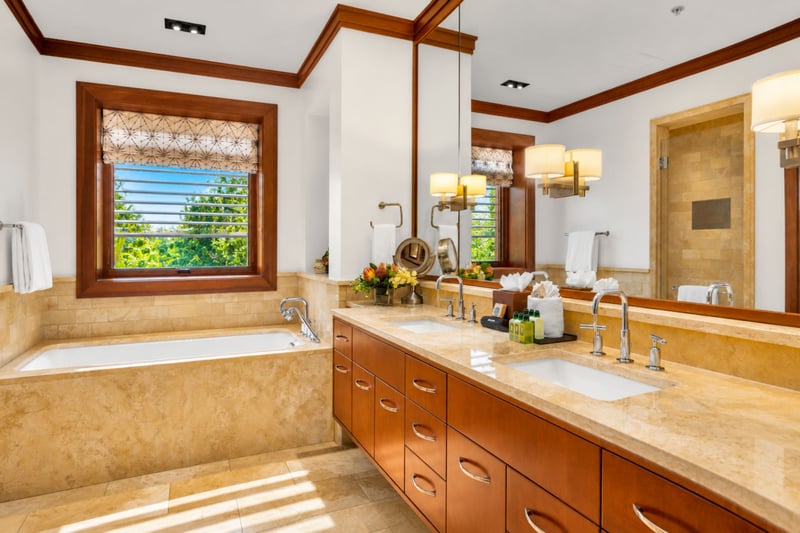 Guest bathroom with dual sink vanity, soaking tub, and a louvered window