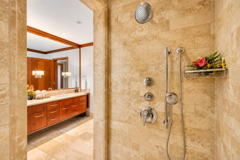 Guest bathroom walk in shower with stone tile, rain shower head, and built in shelf