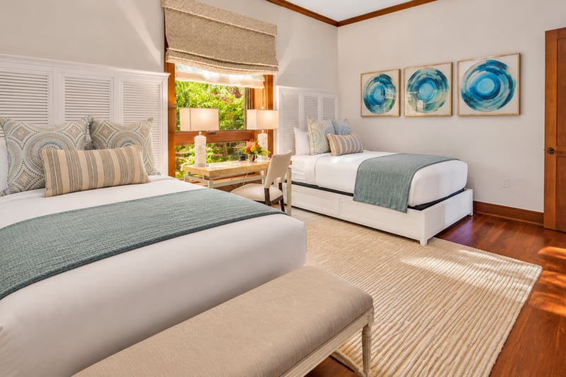 Third bedroom with two beds, writing desk, and garden views