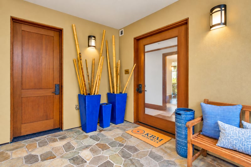Private entry with glass front door, bamboo accents, and a welcoming bench