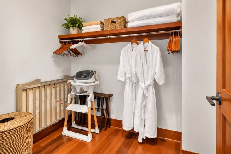 Closet with plush robes, luggage racks, portable crib, and high chair