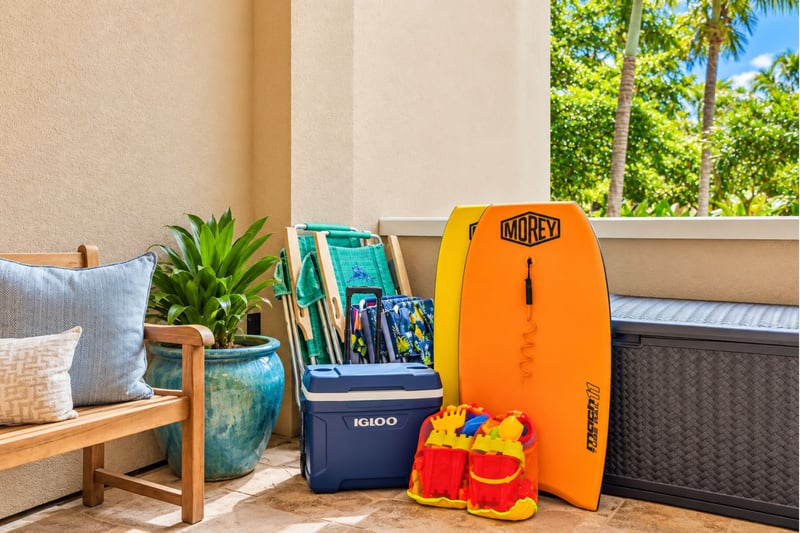 Beach gear for guests including bodyboards, beach chairs, cooler, and sand toys
