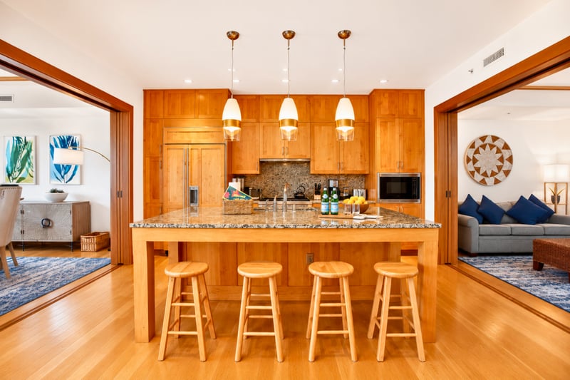 Chef's kitchen at The Resort at Kapalua Bay MON-6301 — granite island seating for four beneath brass pendant lighting