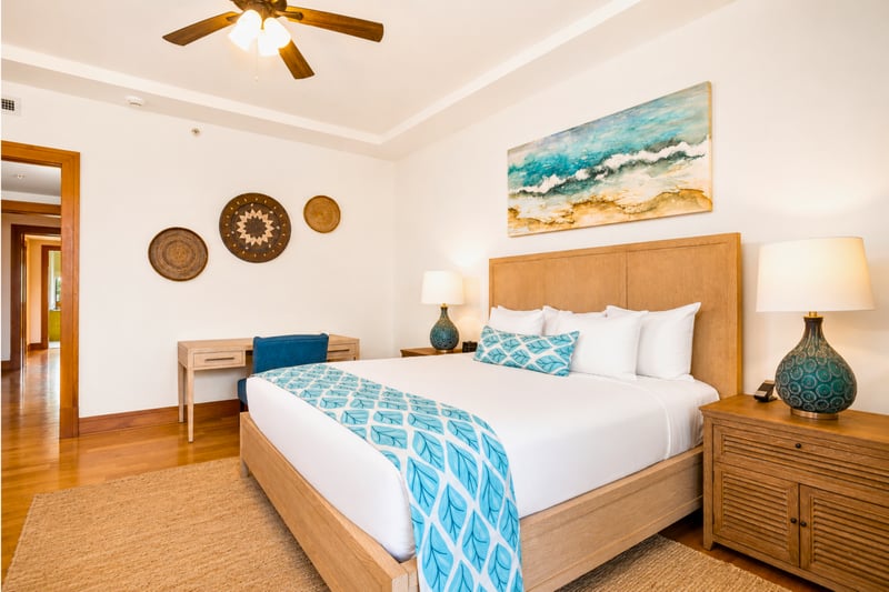 Primary bedroom at The Resort at Kapalua Bay MON-6301 — king bed with tropical garden views through picture windows