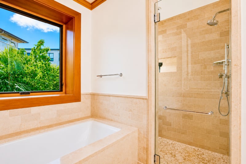 Guest bathroom shower at The Resort at Kapalua Bay MON-6301 — glass-enclosed shower beside a garden-view soaking tub
