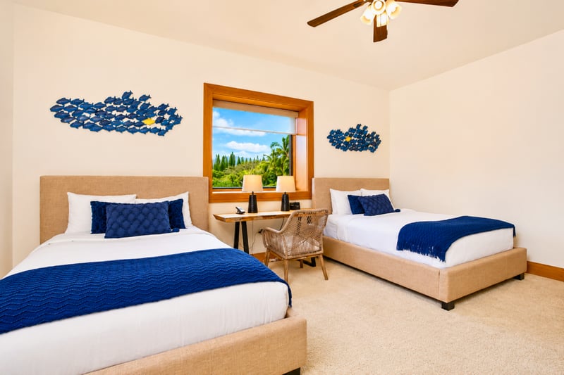 Guest bedroom at The Resort at Kapalua Bay MON-6301 — two beds beneath coastal fish art, with desk and tropical window views