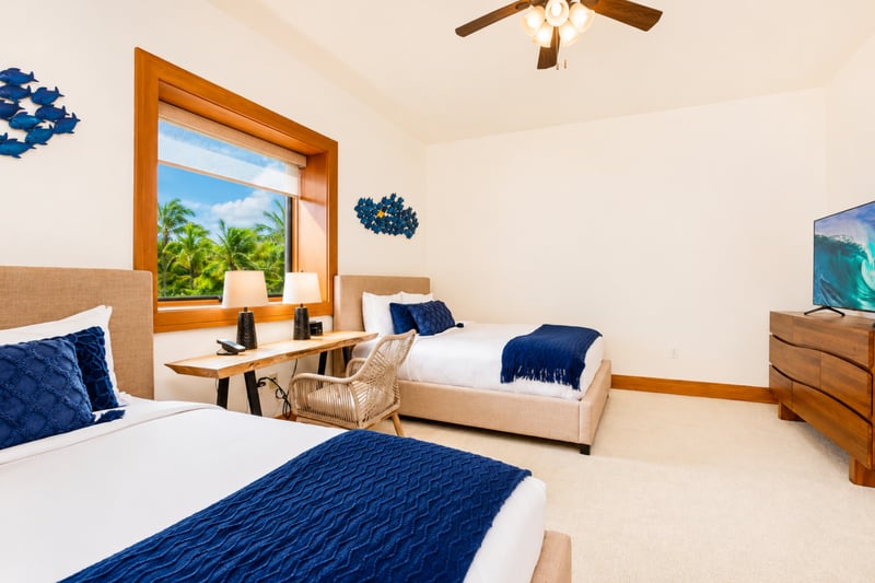 Guest bedroom at The Resort at Kapalua Bay MON-6301 — two beds, smart TV, and a work desk with garden views