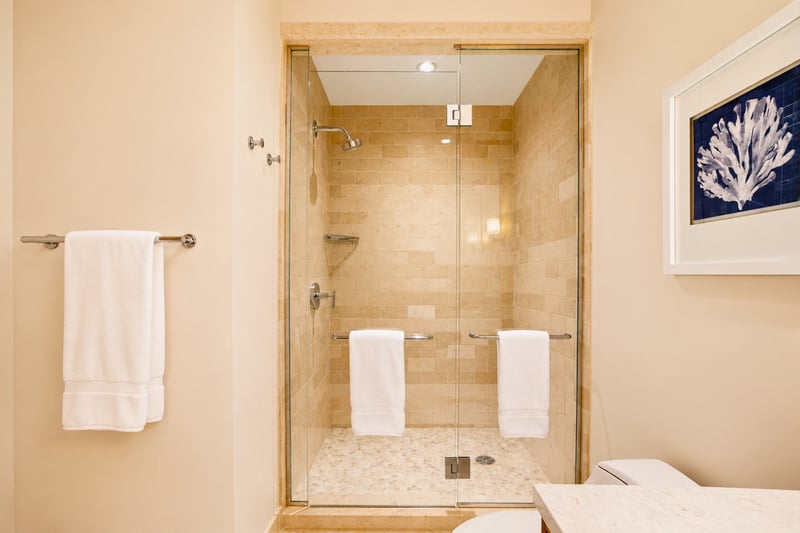Guest bath shower at The Resort at Kapalua Bay MON-6301 — glass-enclosed walk-in shower with dual towel bars