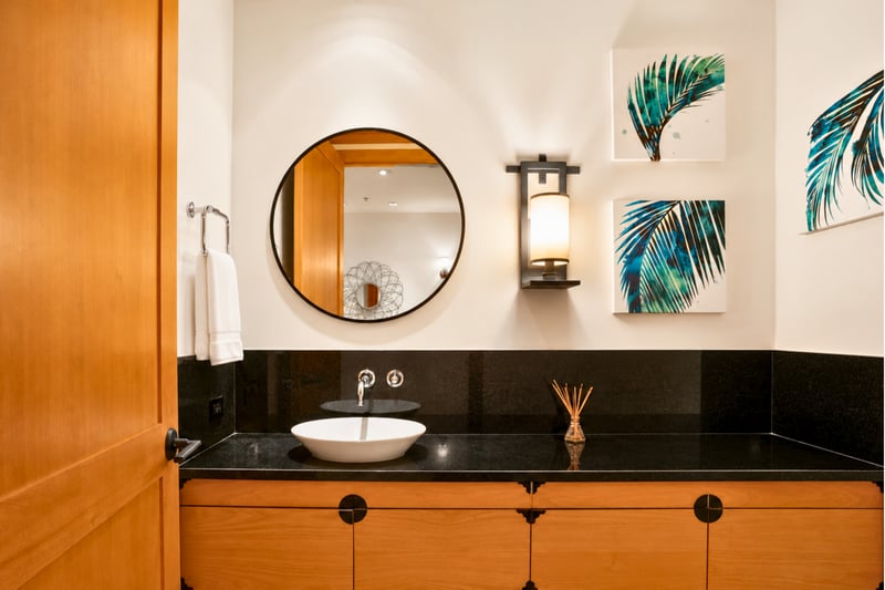 Powder room at The Resort at Kapalua Bay, black granite vessel sink beneath tropical palm-leaf artwork MON-6301