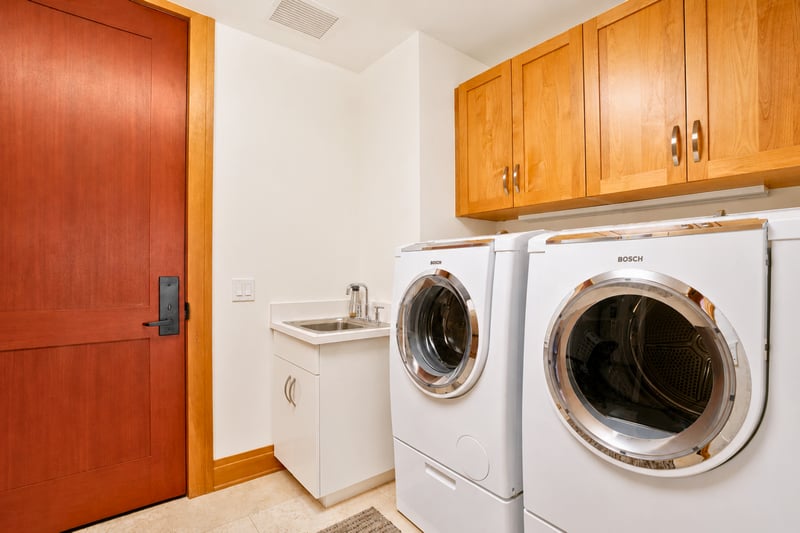 In-unit laundry at The Resort at Kapalua Bay MON-6301 — full-size Bosch washer and dryer with utility sink