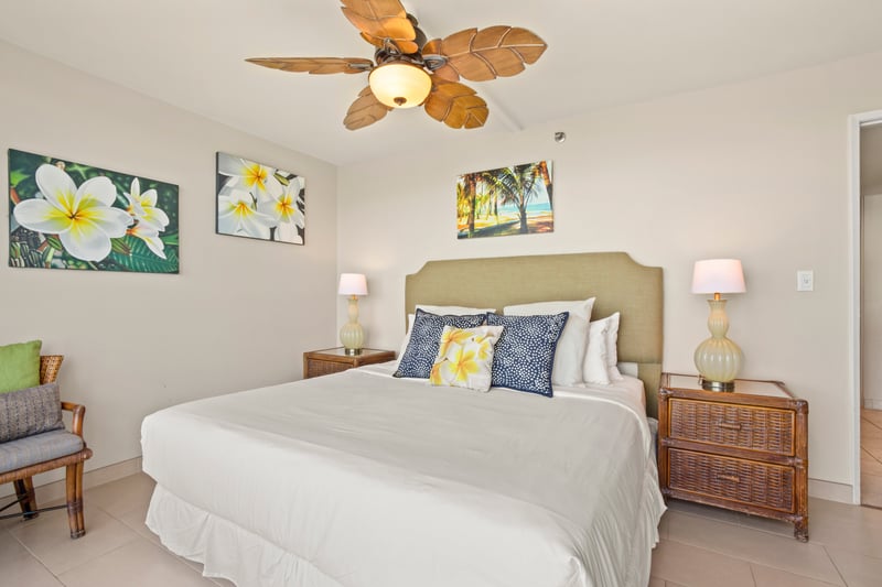 This master bedroom offers a coastal haven with a king bed and floor-to-ceiling windows framing the tranquil sea