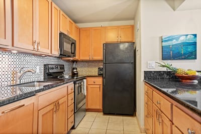 This modern kitchen offers everything you need—sleek appliances, rich wood cabinetry, and coastal charm throughout
