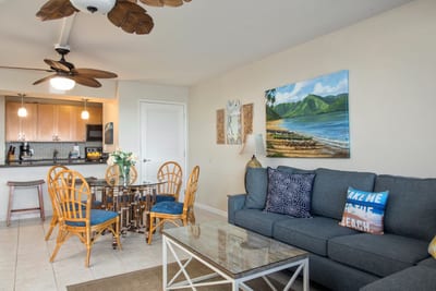 Relax in the living room where palm-leaf fans, plush seating, and coastal charm create the ultimate beachy vibe