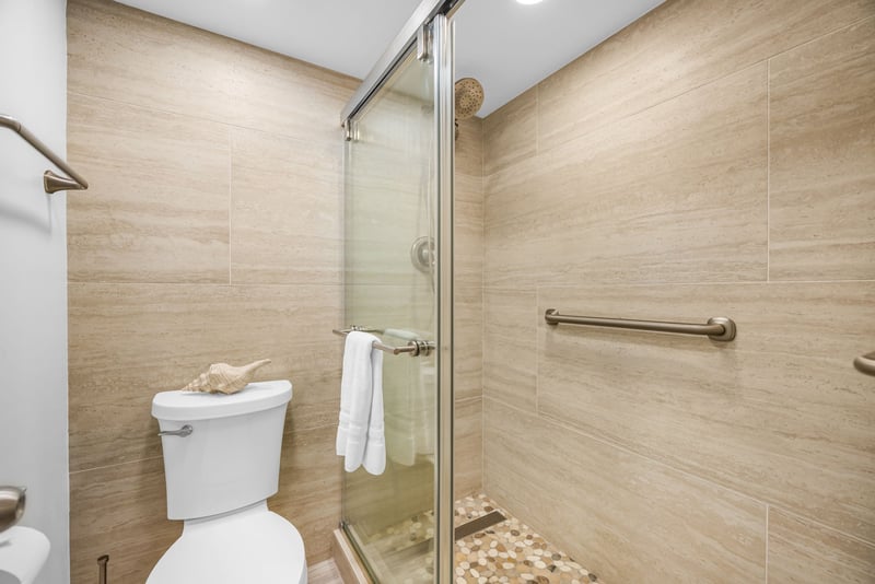 A walk-in shower with glass enclosure and clean tile finishes completes the master bath