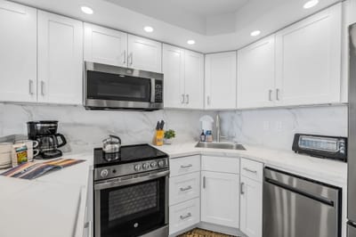 White cabinetry and quartz-style counters keep the kitchen bright and functional from every angle VIR-107
