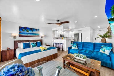 The living area features teal accent furniture and an open layout that draws the eye straight to the lanai VIR-107