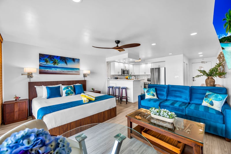 The living area features teal accent furniture and an open layout that draws the eye straight to the lanai