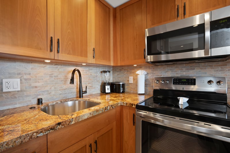 A chef-ready kitchen featuring stone-inspired surfaces, elegant wood tones, and a spacious prep island awaits WH1-1211