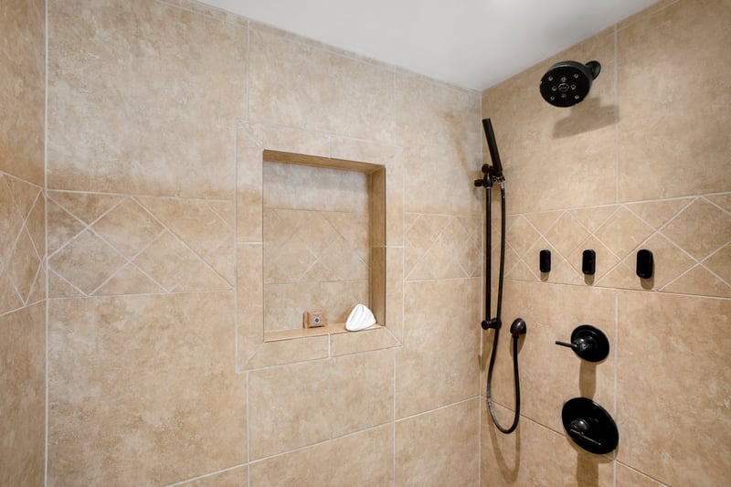 Earthy tile, shower, and warm wood finishes offer an elegant retreat with ocean-view vibes WH1-1211