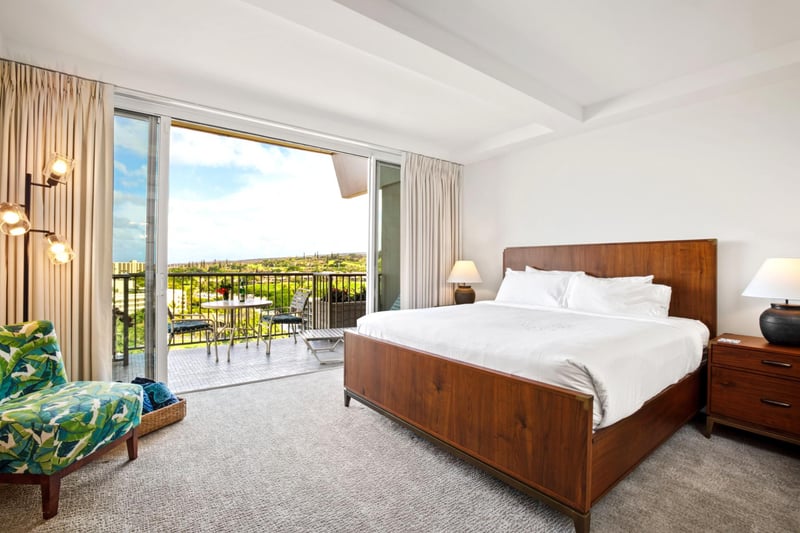 Framed by floor-to-ceiling glass, this tranquil escape opens to balcony views of island peaks and blue