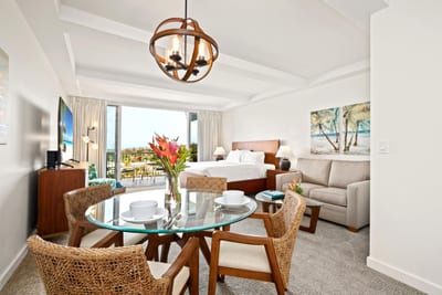 Enjoy open-concept dining with tropical florals, beach-inspired art, and seamless views into the relaxing living space