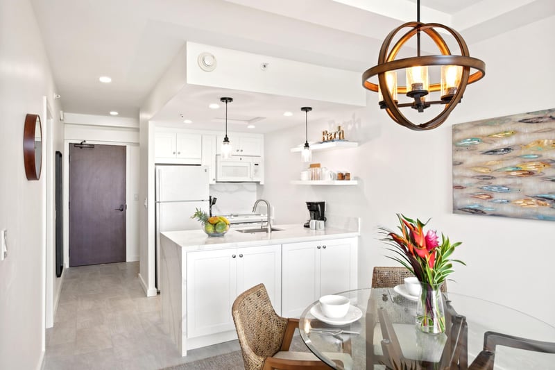 This light-filled dining space features natural textures, seaside artwork, and elegant flow into the living area