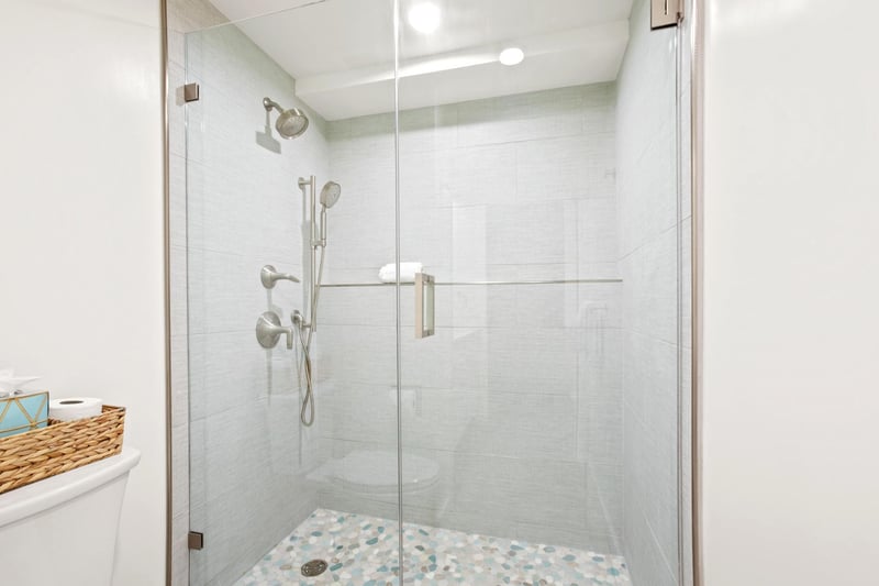 Clean lines and warm wood tones balance white stone and glass in this spa-like, serene retreat