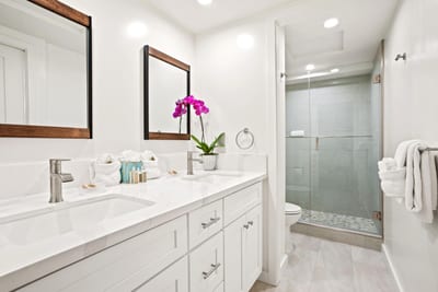 Framed mirrors, artisanal tile, and soft lighting create an organic, upscale spa experience